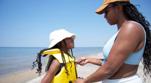 mother fastening daughter's PFD